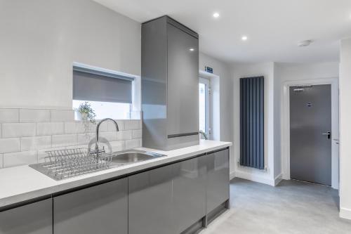 a white kitchen with a sink and a window at Luxury York Stay,Mini Hotel, Hartlepool City Centre in Hartlepool