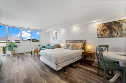 a bedroom with a bed and a dining room with a table at Top of the Gulf 410 - Beach Front Resort Condo - RENOVATED LIKE NEW in Panama City Beach