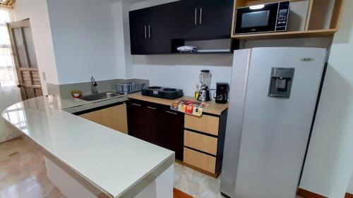cocina con nevera blanca y microondas en Hermoso Apartamento en Ipiales, en Ipiales