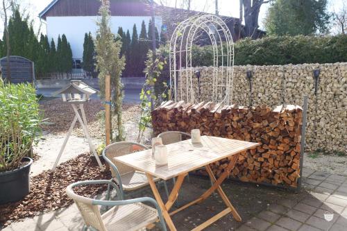 a table and chairs in a garden with a fence at FeWo Schönwetter in Weßling