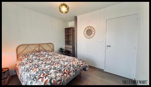 1 dormitorio con cama y pared blanca en Villa Saint Mart', en Bréhal