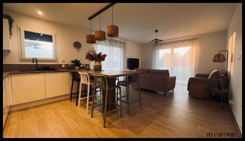 cocina y sala de estar con mesa y sillas en Villa Saint Mart', en Bréhal