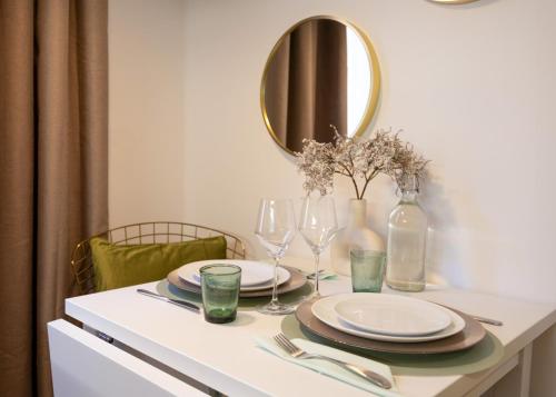 una mesa con platos, gafas y espejo en Le 34, en Saint-Tropez