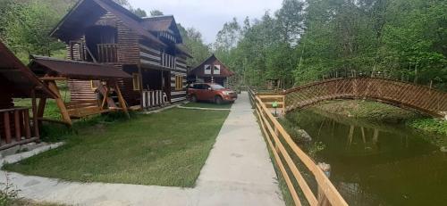 ein Haus mit einem Auto neben einer Brücke in der Unterkunft La Mylii in Berevoeşti