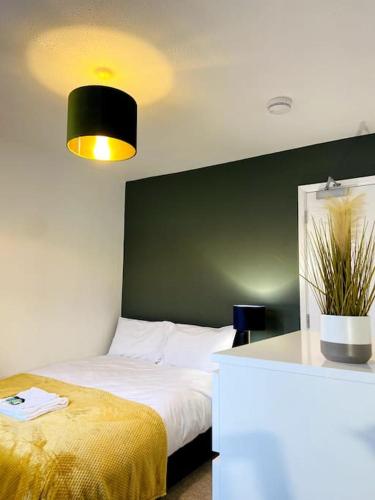 1 dormitorio con cama y pared verde en Modern and Comfy 5 Bed Home, Wi-FI, Free Parking! en Cambridge