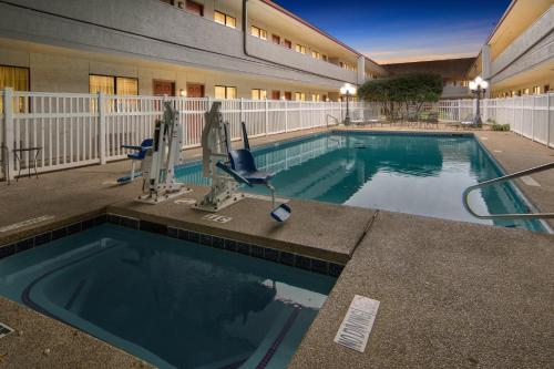 a large swimming pool in front of a building at Red Roof Inn & Suites Irving - DFW Airport South in Irving