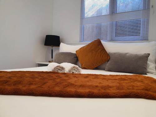 a white dog laying on top of a bed at Stunning 1 King bed cabin in Grays in Grays Thurrock