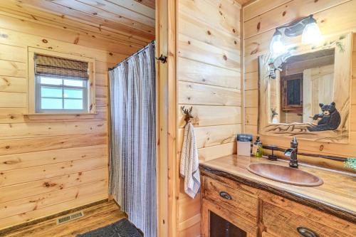 a log cabin bathroom with a sink and a mirror at Dog-Friendly Cabin with Fire Pit and Hot Tub! in Murphy