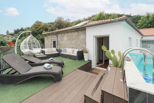 a backyard with a patio furniture and a swimming pool at Casa da Torre in Vieira do Minho