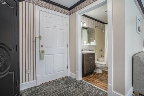 a bathroom with a white door and a toilet at Harbor House Inn in Grand Haven