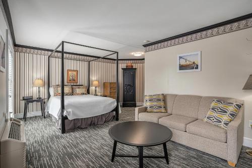 グランド・ヘイブンにあるHarbor House Innのベッドとソファ付きのホテルルーム