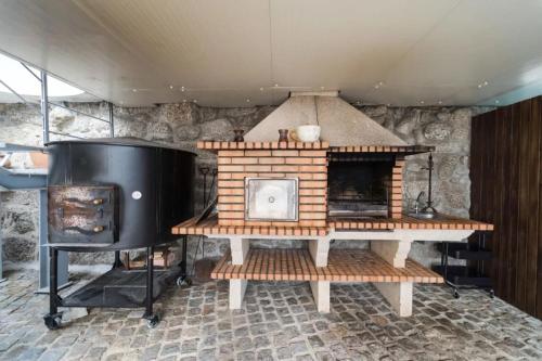 a brick fireplace with a stove in a room at Casa da Torre in Vieira do Minho