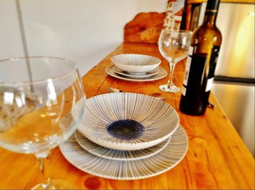 een tafel met glazen en borden en wijnflessen bij Loft rural in Granada