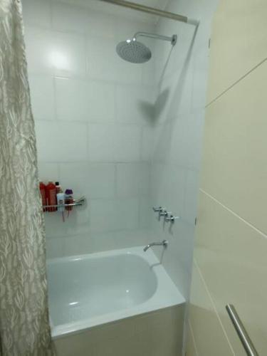 a bathroom with a tub and a shower with a shower at Departamento Amoblado de lujo! in Pilar