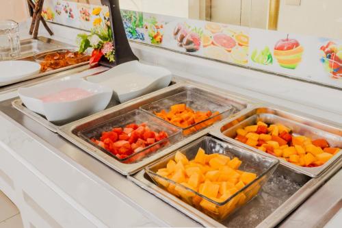 a buffet line with trays of fruits and vegetables at Paris FC Hotel in Poza Rica de Hidalgo