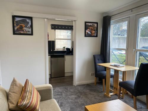 een woonkamer met een bank en een tafel bij East Coast City Centre Dunfermline Apartment in Fife