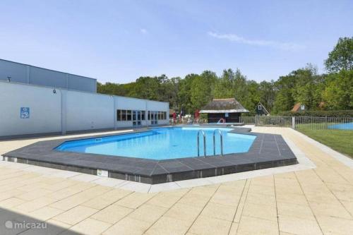 una gran piscina en un patio en Luxe 6-persoons vakantiewoning Gramsbergs Huuske, en Gramsbergen