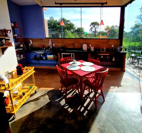 comedor con mesa roja y sillas rojas en Amanduarte Brasília, en Brasilia