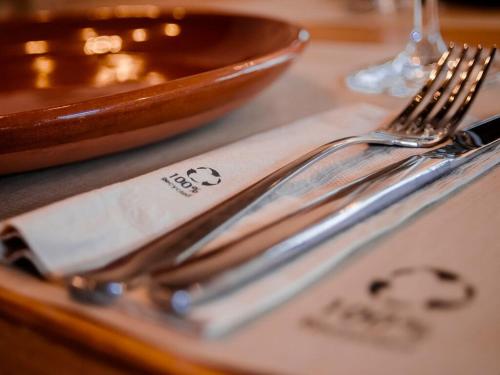 a table with two silver utensils on a napkin at Aldea Rural Pazos De Arenteiro in Pazos de Arenteiro