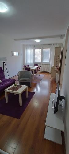 a living room with a couch and a table at Lovely square apartment Purple Velvet 43 Macedonia Stree in Skopje