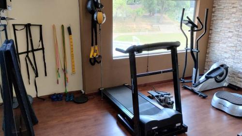 a room with a gym with a treadmill and other equipment at Hotel Portón Sabaneta in Sabaneta