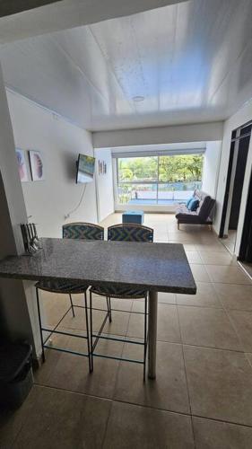 a room with a table and chairs and a living room at Denier House Guabinal Apto 2 in Ibagué