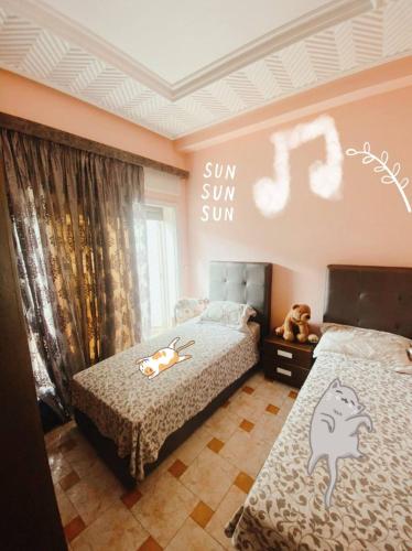 1 dormitorio con 2 camas y un cartel que lee Sun Sum en Tanger City, en Tánger