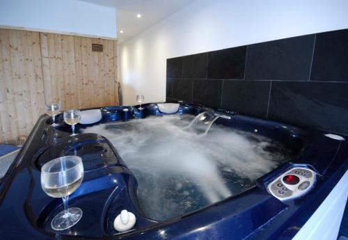 una vasca da bagno riempita d'acqua con bicchieri da vino di Warren Farm Farmhouse nr Oxford a Culham