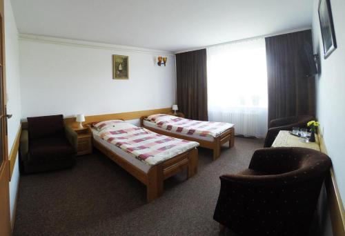 ein Hotelzimmer mit 2 Betten und einem Stuhl in der Unterkunft Vanillia in Siestrzeń