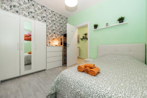 a bedroom with a bed with an orange towel on it at Lotus - Apartment sul mare con giardino in Lido di Ostia