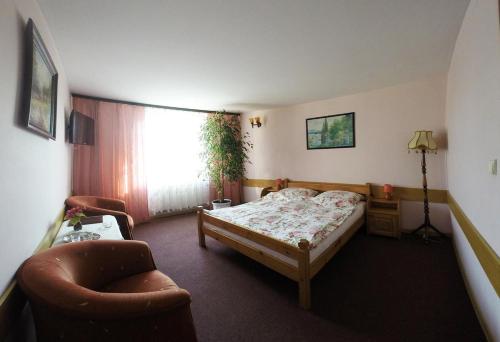 um quarto com uma cama, uma cadeira e uma janela em Vanillia em Siestrzeń