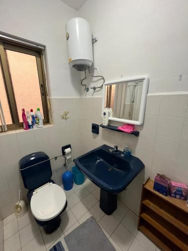 a bathroom with a blue sink and a toilet at Seafront Apartment with Amazing Sunset View in Xlendi