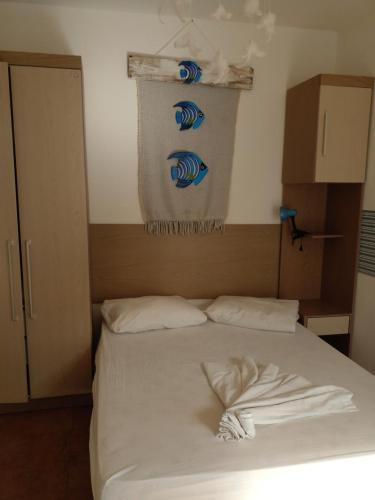 a bedroom with a bed with white sheets at Hotel Villa De Carli Beach in Rio Grande