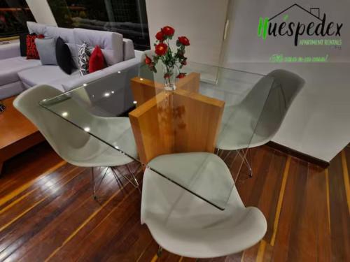 a glass table and chairs in a living room at Hermoso 1Hab+2baños apartamento en el Bosque,Ccs in Caracas