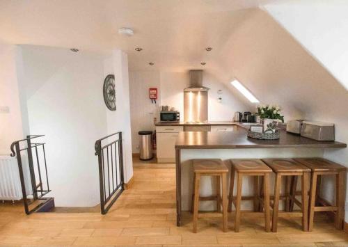 cocina con encimera y taburetes en una habitación en Creel Cottage (No.3), en Arbroath