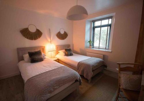 a bedroom with two beds and a window at Creel Cottage (No.3) in Arbroath