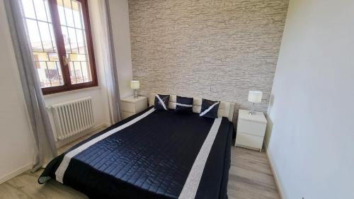 een slaapkamer met een bed en een bakstenen muur bij Sole del Garda in Lazise