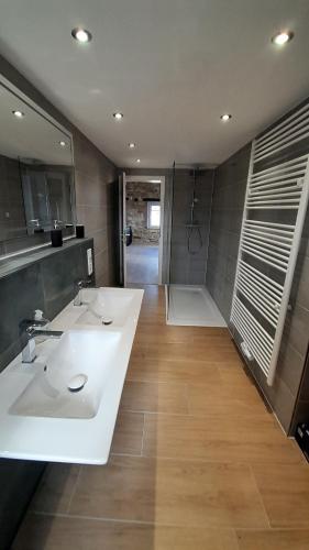 uma casa de banho com 2 lavatórios e um chuveiro em Ferienwohnung Plintho em Oberthal