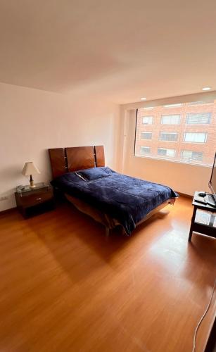um quarto com uma cama e uma grande janela em Apto amplio en chico - calle 100 em Bogotá