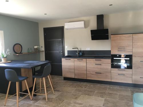 une cuisine avec des armoires en bois et une table avec des chaises dans l'établissement Lou Mas des oliviers, à Mazan