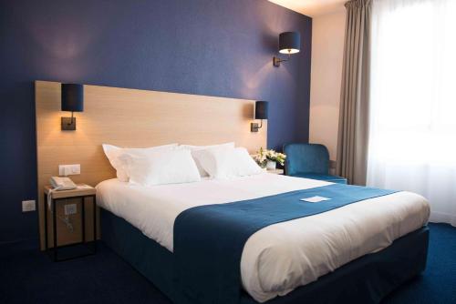 een hotelkamer met een groot bed en een stoel bij Best Western Hôtel Le Sud in Manosque