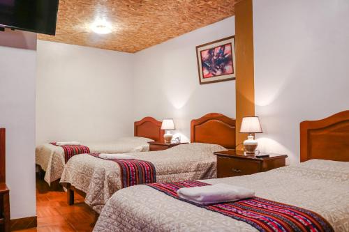 a hotel room with three beds in a room at Las Torrecitas in Carhuaz