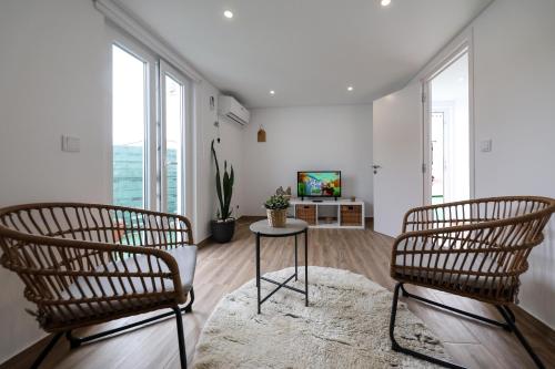 a living room with two chairs and a table at Casas com Amoras in Serra da Pescaria in Famalicão