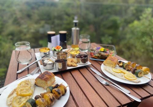 a wooden table with plates of food on it at Mākoha PurePod in Kerikeri