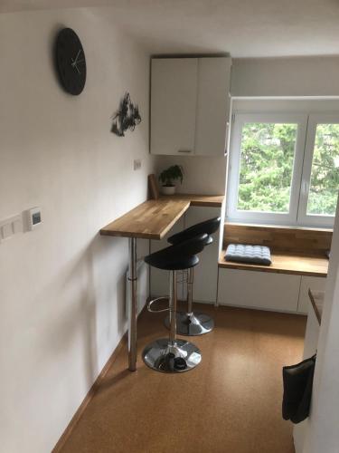 a small kitchen with a table and two stools at Útulný apartmán na Divadelní in Český Těšín