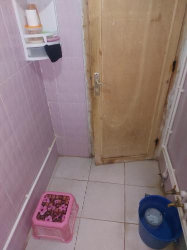 mała łazienka z różową toaletą i drzwiami w obiekcie Dar Dyafa w mieście Ar-Raszidijja