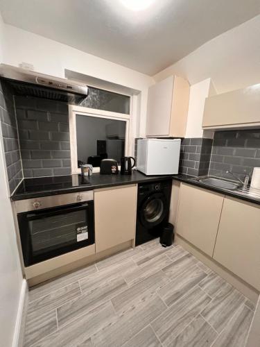 a kitchen with a washer and dryer in a room at 82a Nelson Street in Kettering