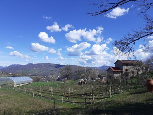 a farm with a fence and a building and a field at Cà Gennara Agri B&B in Porretta Terme