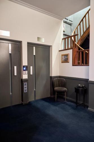 a waiting room with a chair and a staircase at SoHo Athinas 60 in Athens