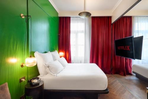 a bedroom with a white bed and green walls at SoHo Athinas 60 in Athens